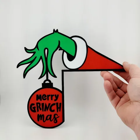 Enfeite de canto com mão verde segurando bola de natal