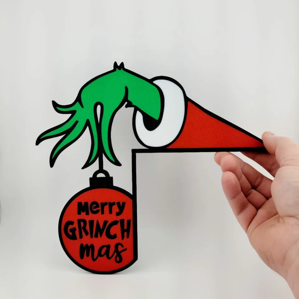 Enfeite de canto com mão verde segurando bola de natal